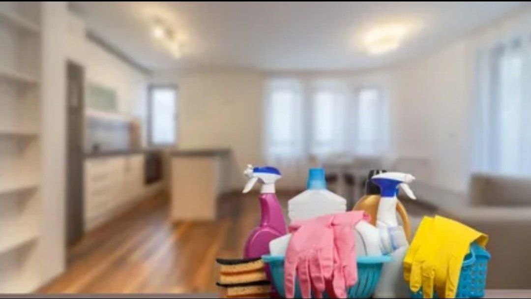 A man and a woman are cleaning a living room with a vacuum cleaner.