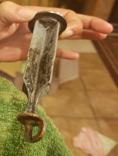 A person is holding a piece of metal in their hand.