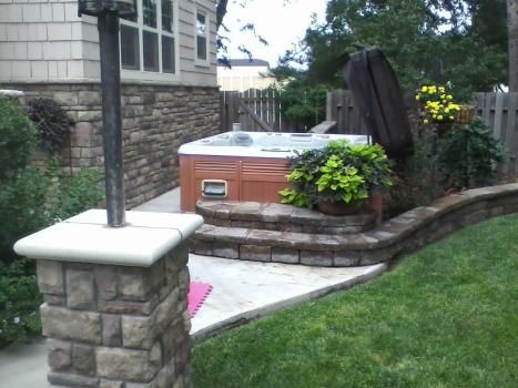 A hot tub sits in the backyard of a house