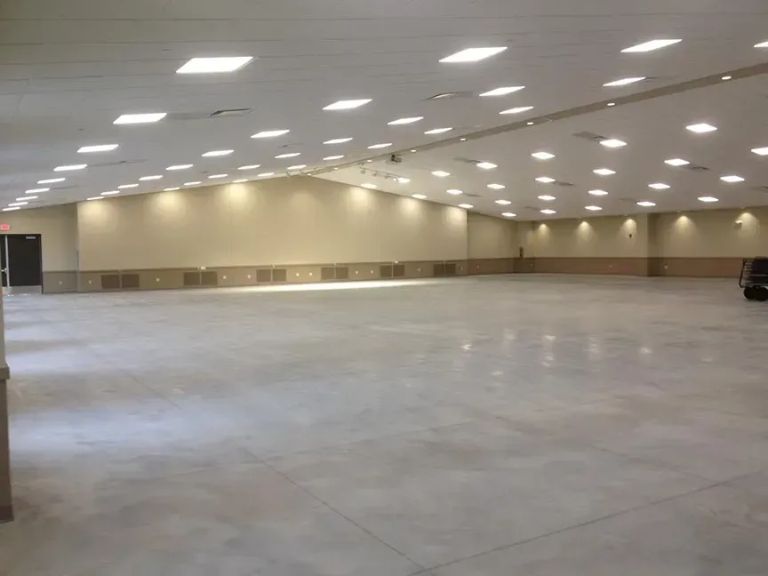 Empty large indoor hall with white ceiling lights and beige walls