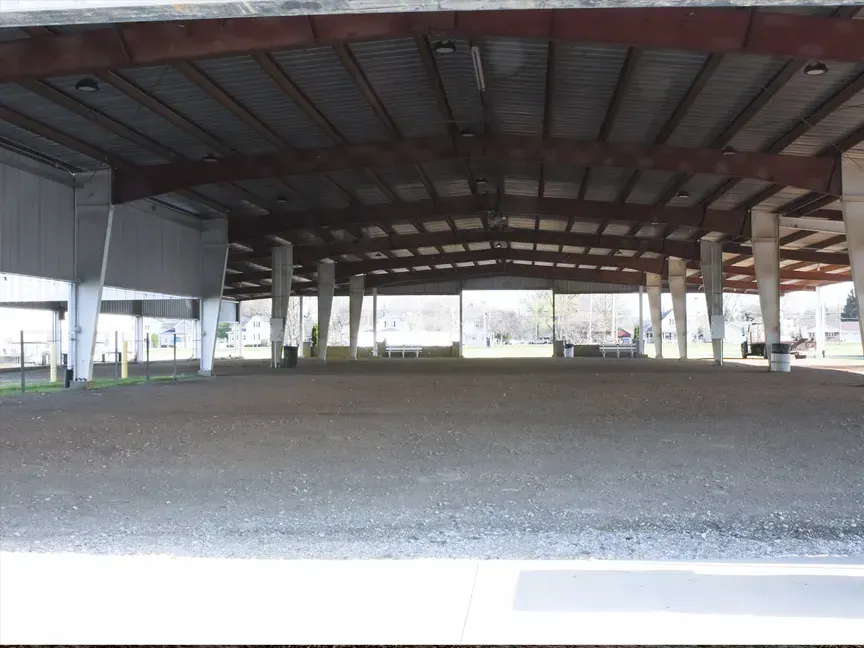 Empty covered pavilion with metal roof and gravel ground, open sides and supporting columns