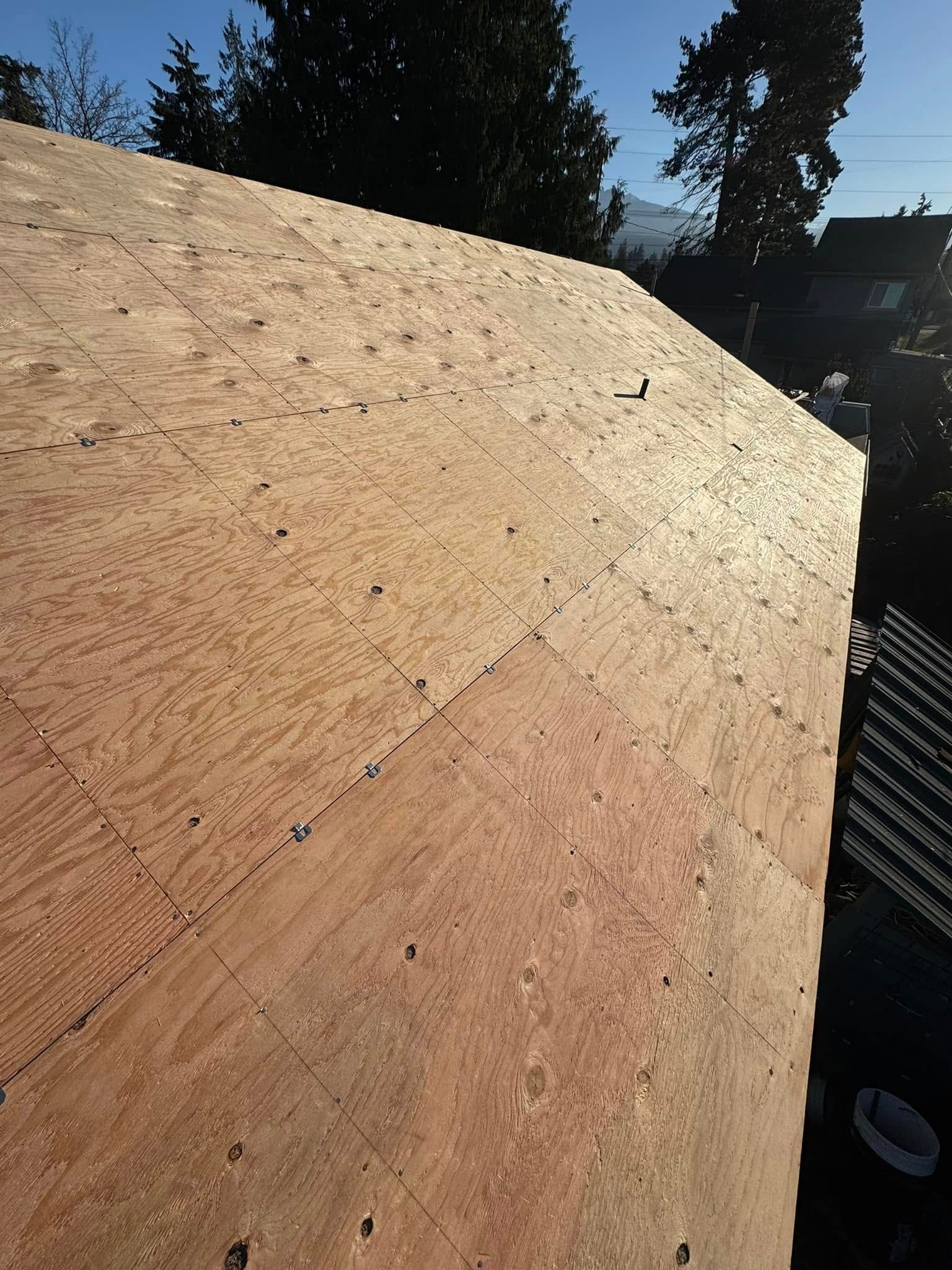 Plywood roof decking on a structure, seen from an angle outdoors in sunlight.