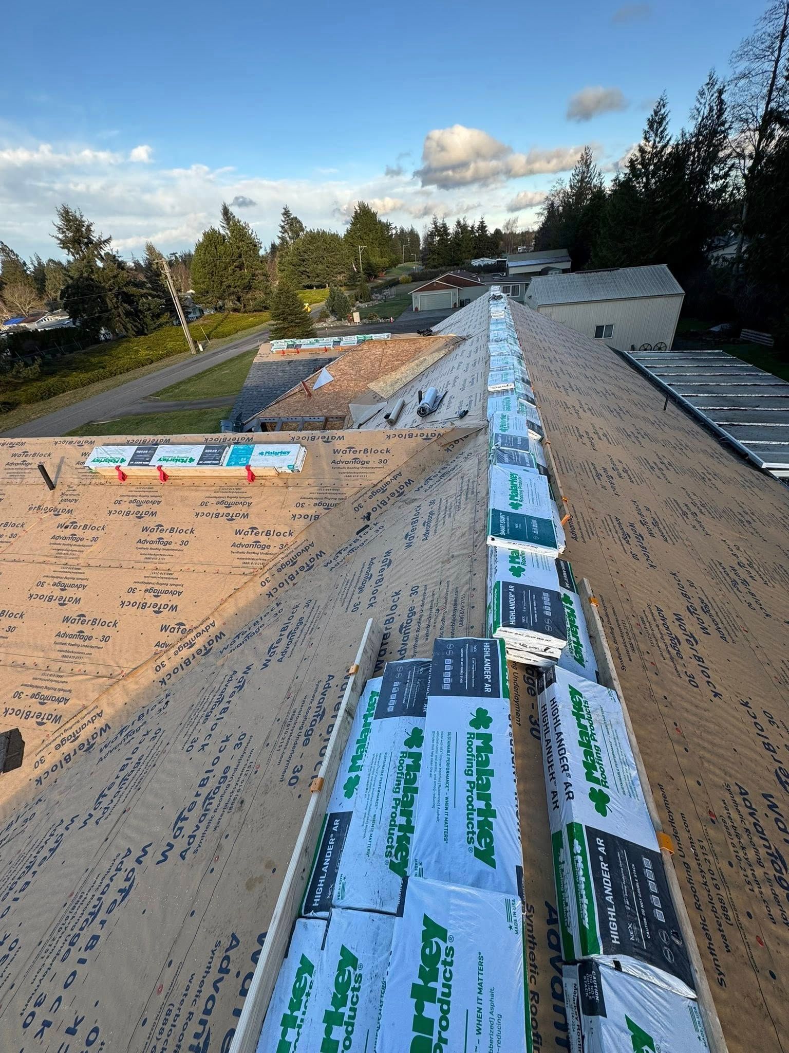 Roofing materials on a partially completed roof; view from above.