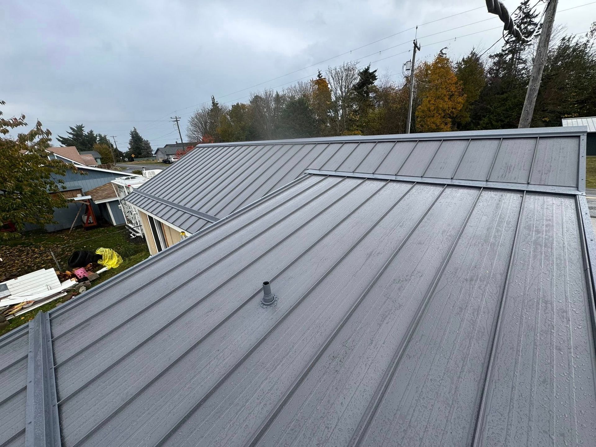 Gray metal roof of a house on an overcast day.