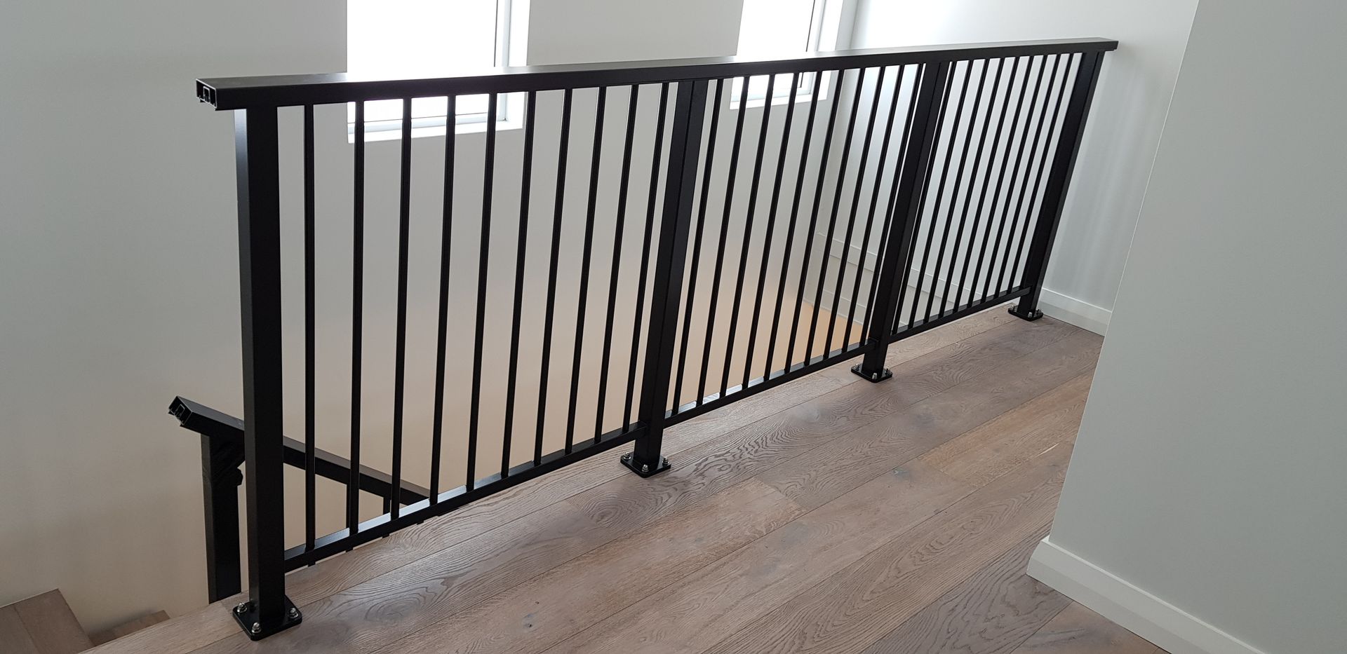 Black metal railing on carpeted stairs.