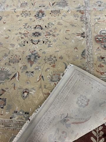 Patterned beige rug with a folded white map or paper in the lower right corner
