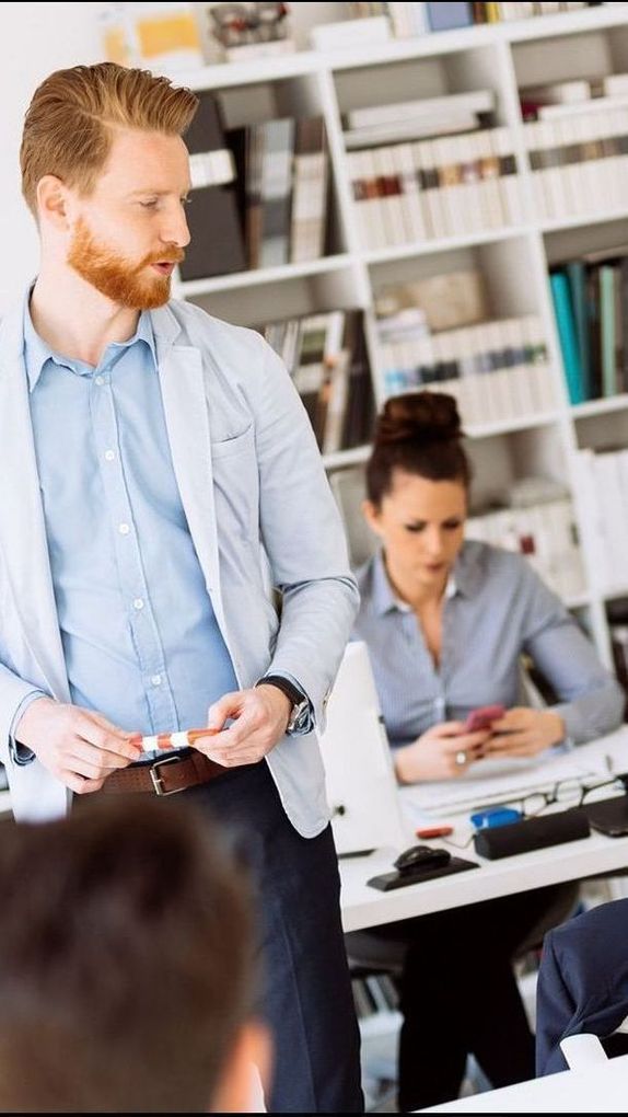 A man is giving a presentation to a group of people in an office.