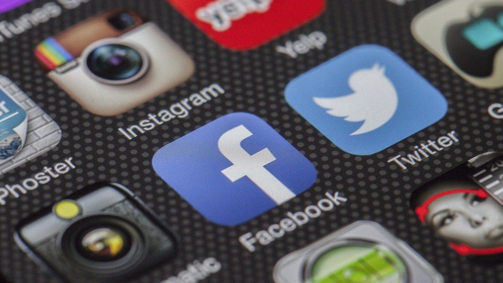 A close up of a cell phone screen with social media icons on it.