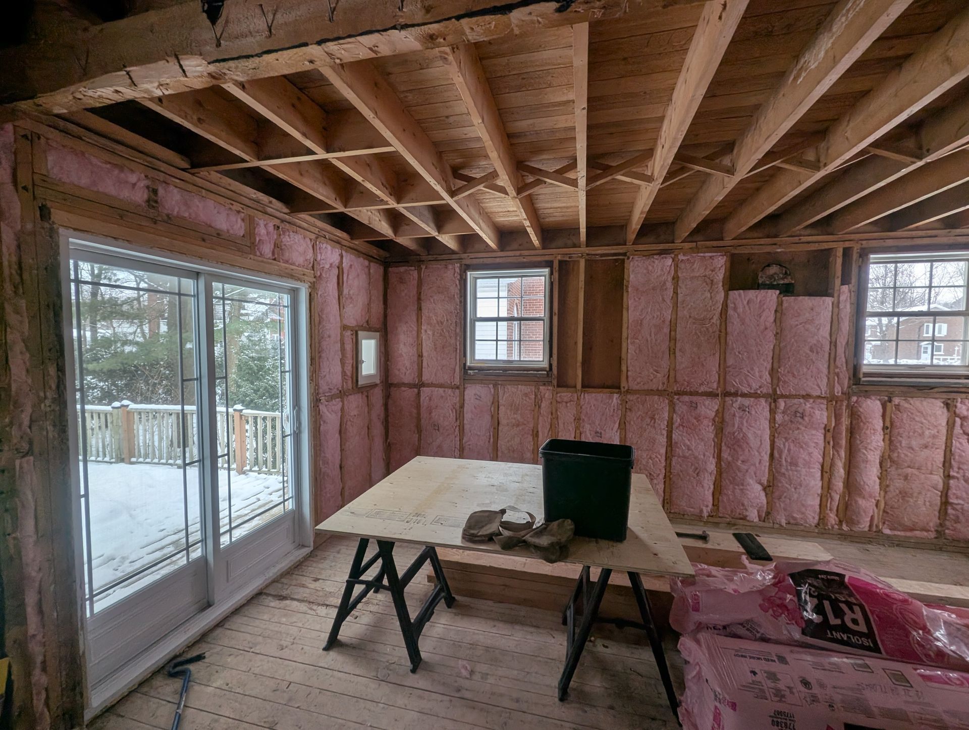 Une pièce avec une table et beaucoup de fenêtres en construction.