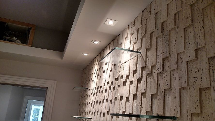 A wall with a pattern on it and shelves on it.