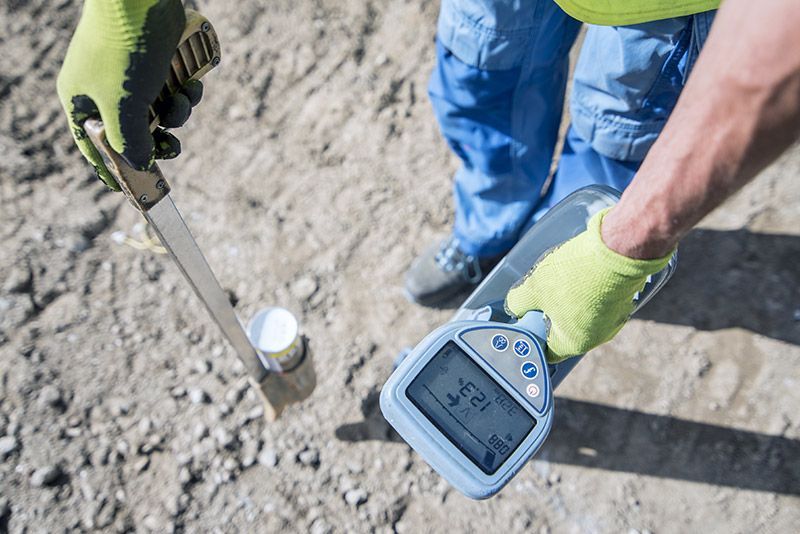 A person is holding a metal object and a device in their hand.