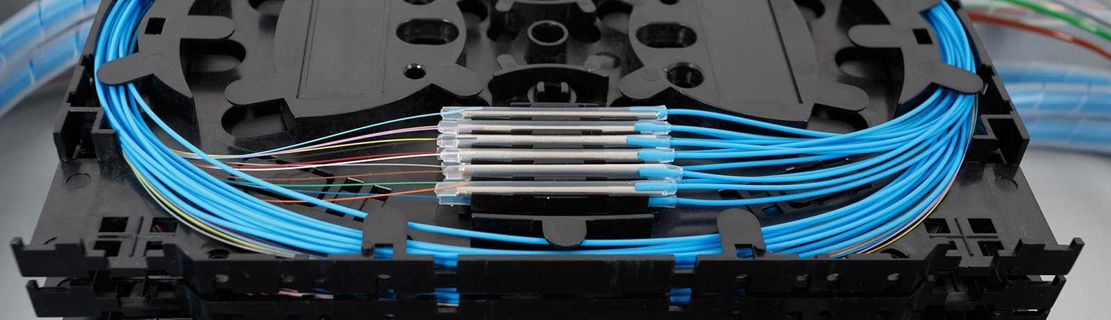 A close up of a splitter with blue wires coming out of it.