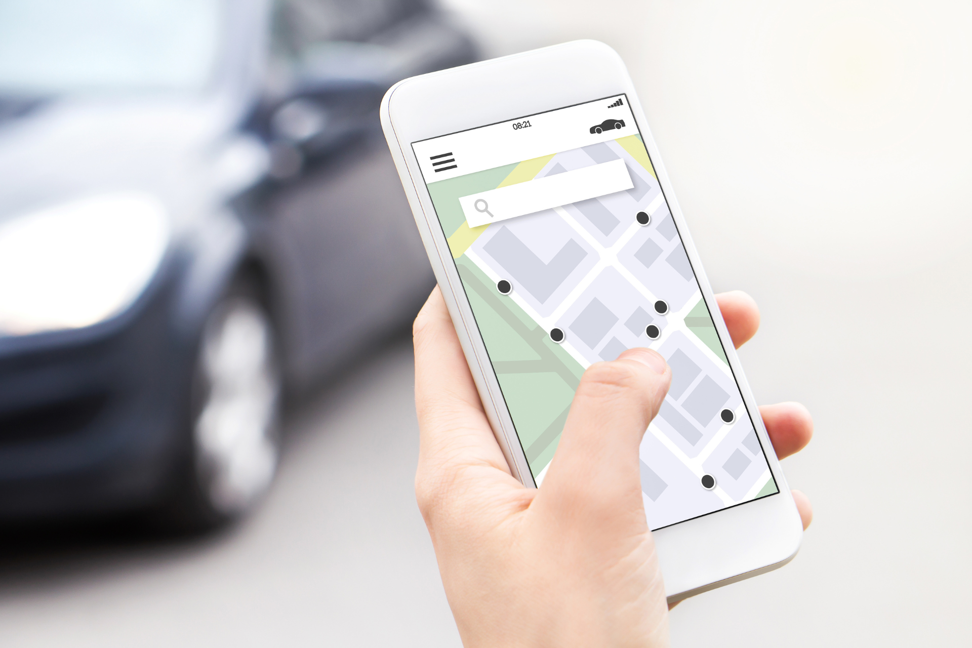 Hand holding a smartphone with a ride-sharing app open, showing a map with available cars.