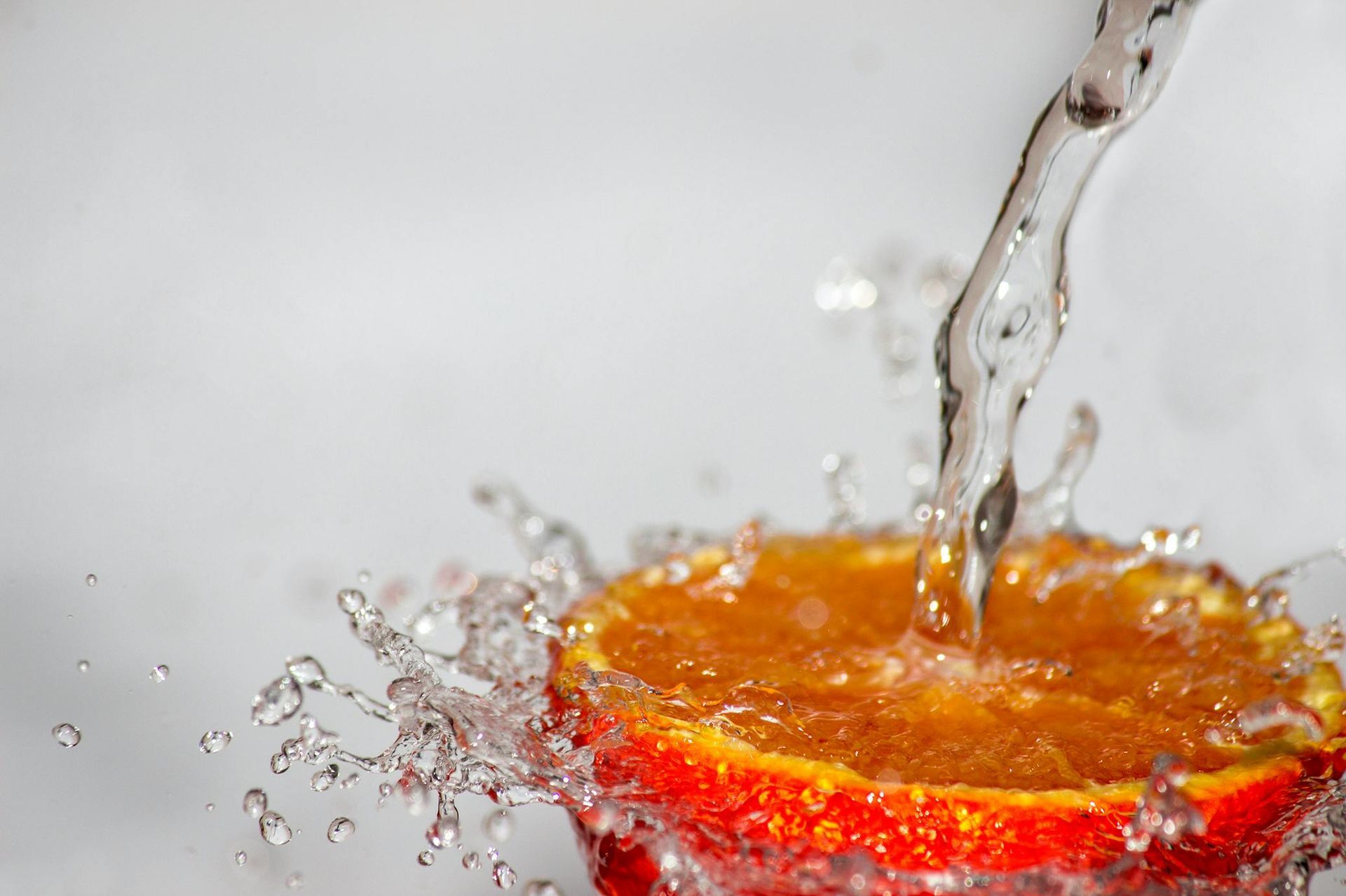 Une tranche d'orange est éclaboussée d'eau.