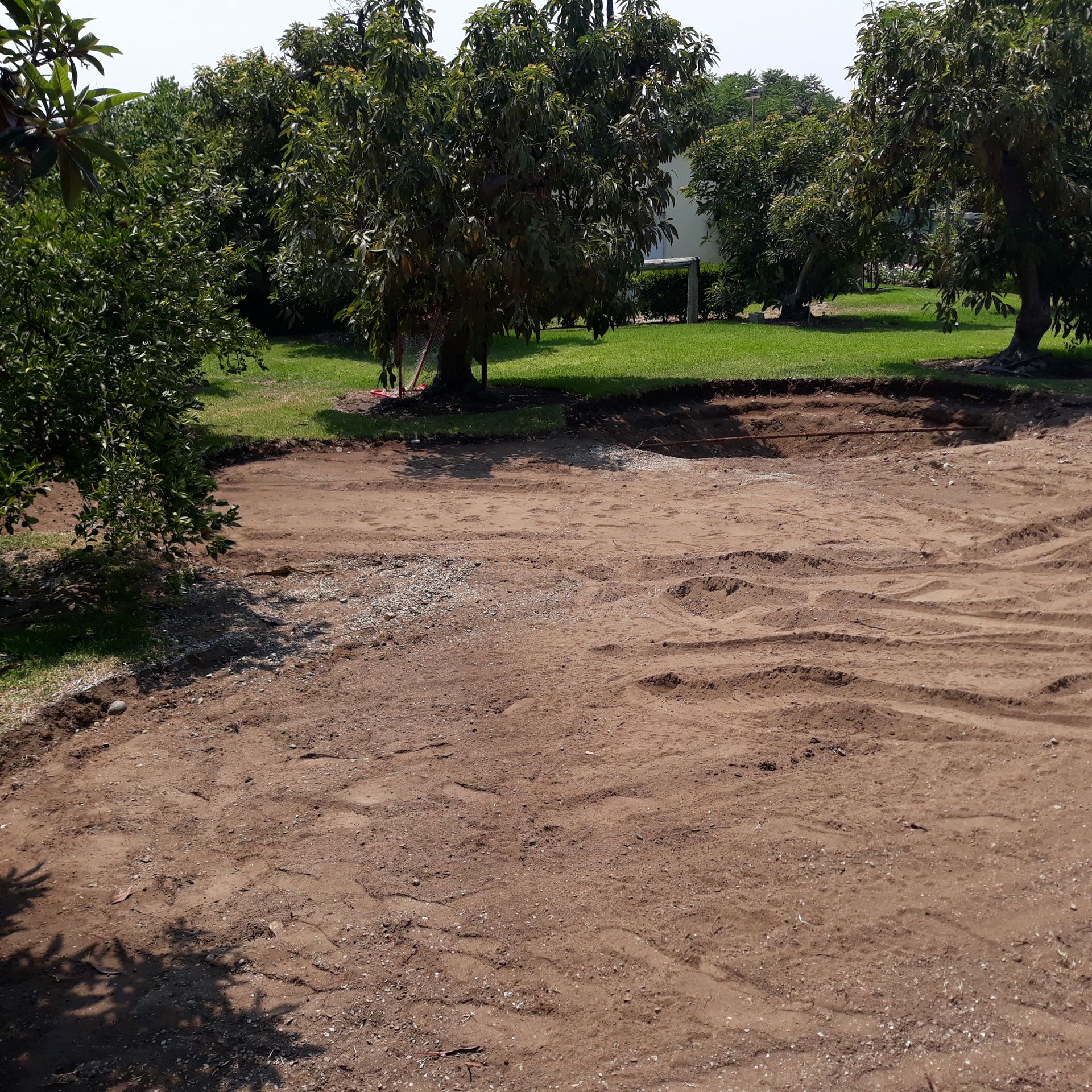 dirt back yard before putting green installation