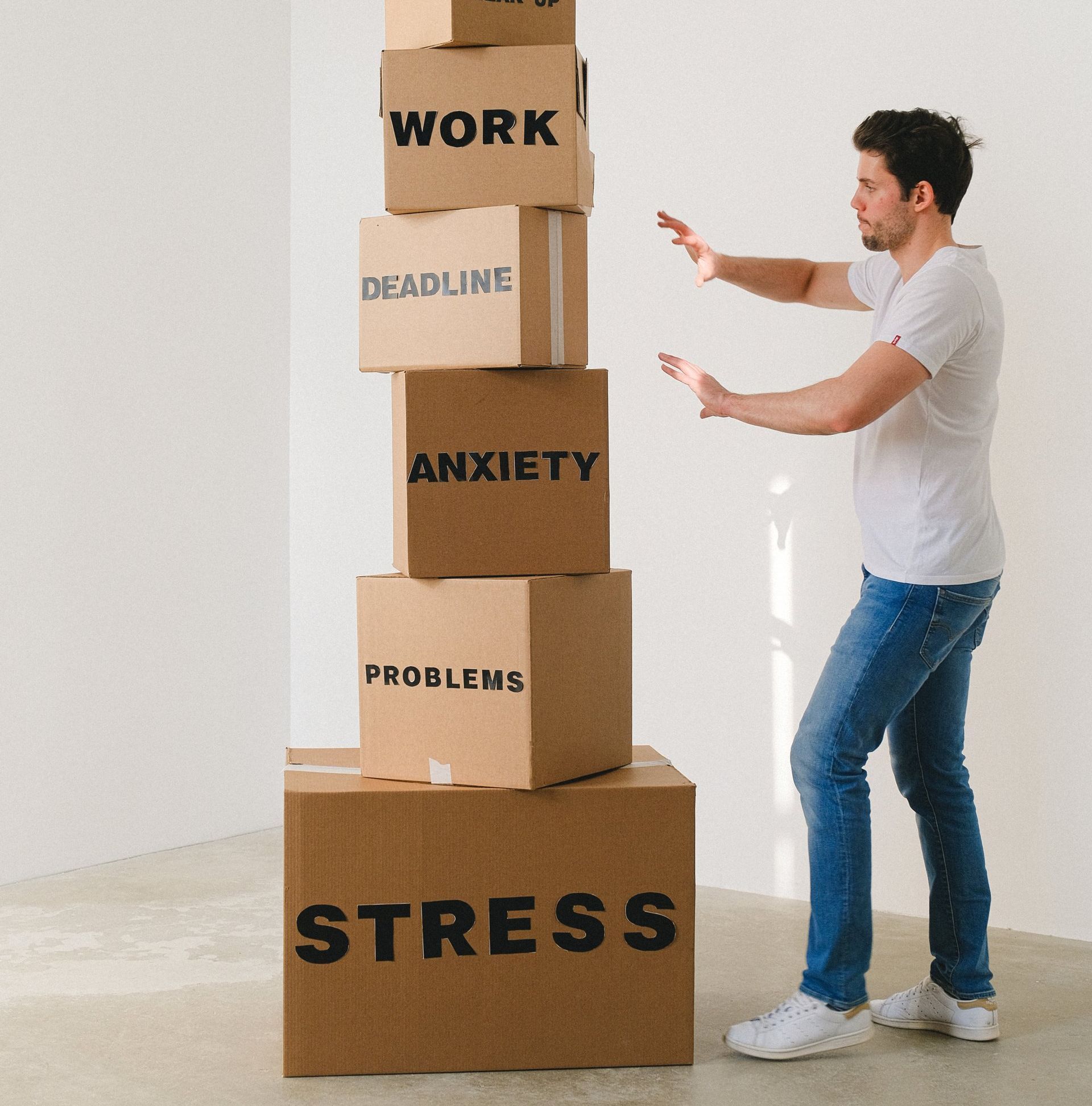 a man is standing next to a stack of cardboard boxes with the word deadline on them .
