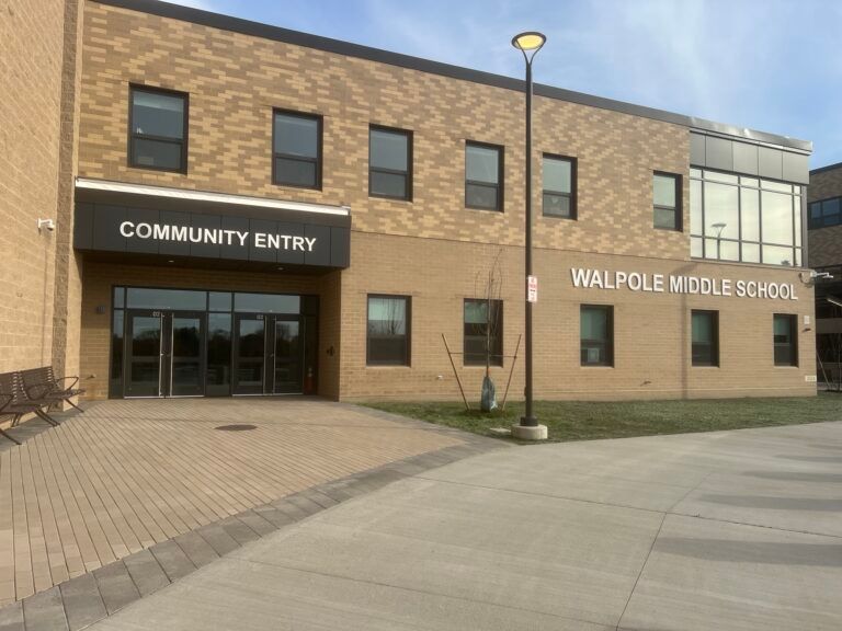 Walpole Middle School community entry on a brick building with glass doors and a paved entrance