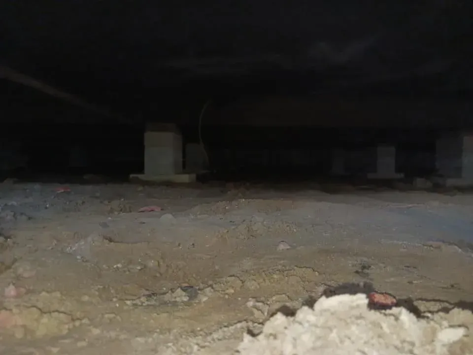 Dark crawlspace with concrete piers supporting a wooden floor. Dark crawlspace with concrete piers supporting a wooden floor.