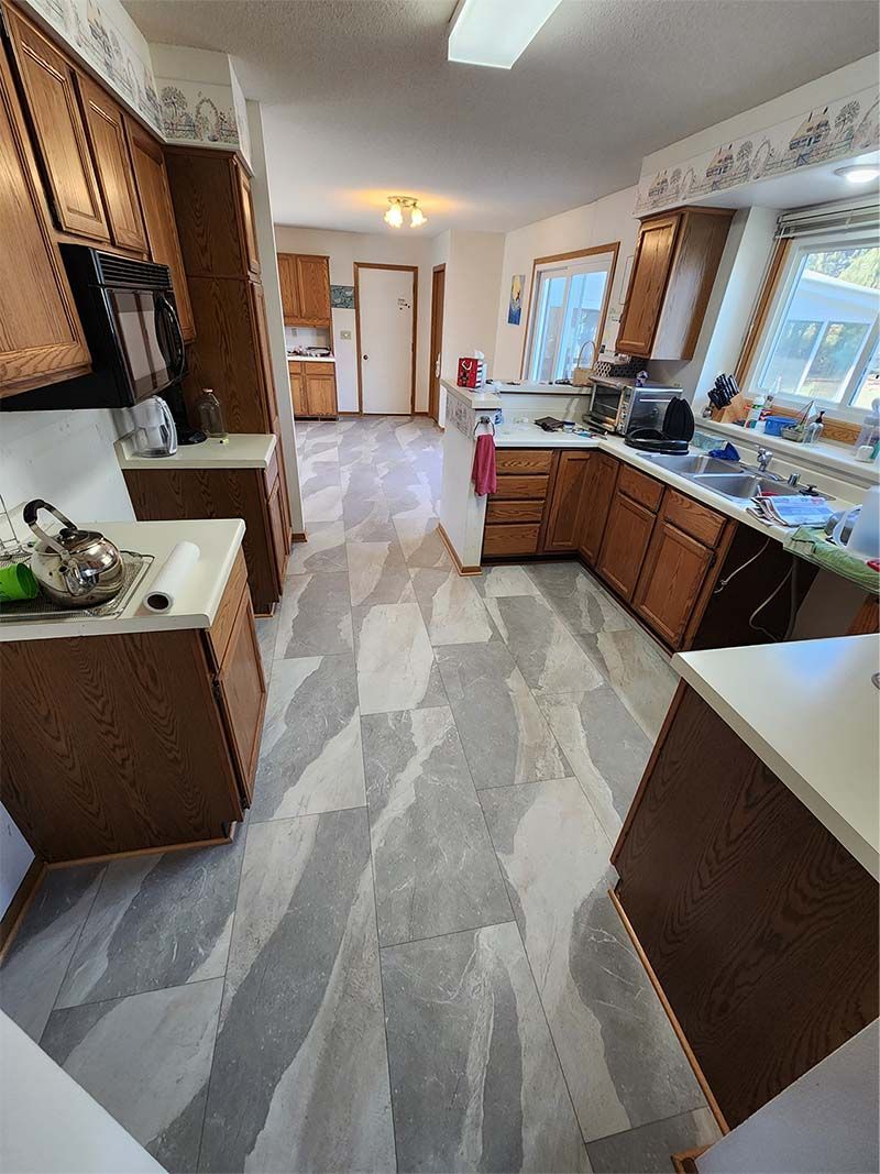 A kitchen with wooden cabinets and a tiled floor.