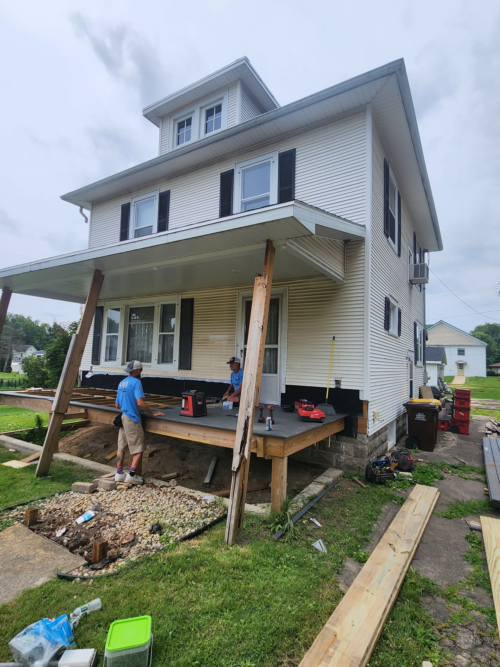 A man is standing in front of a house that is being moved.