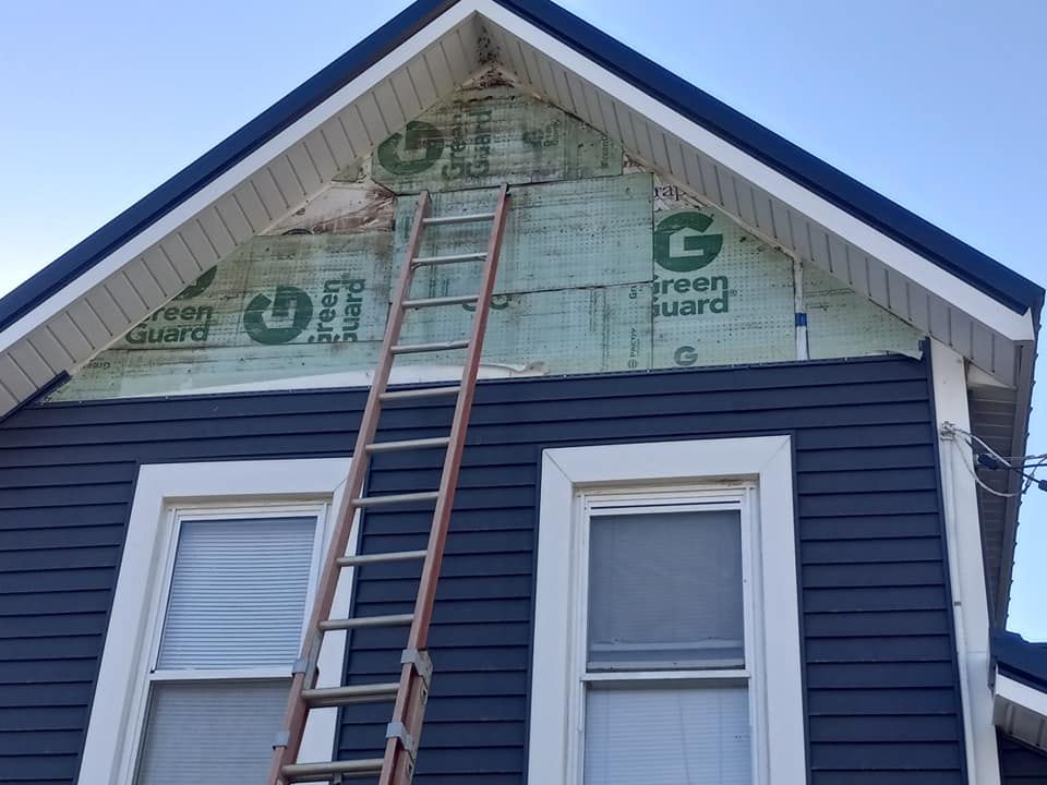 A ladder is sitting on the side of a house.