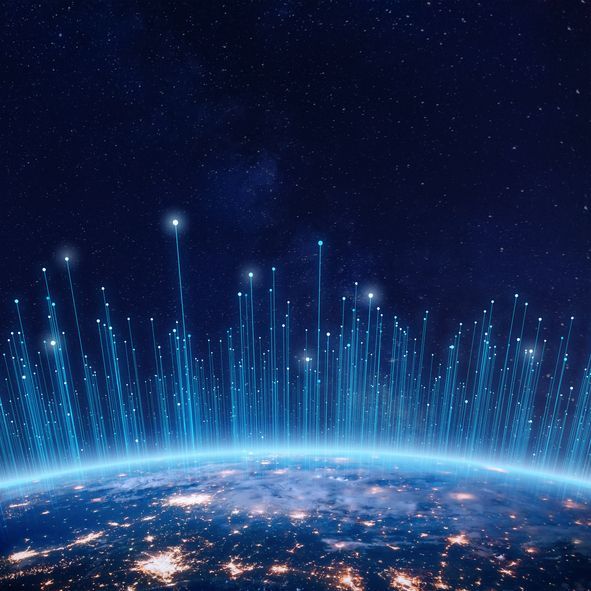An aerial view of the earth at night with lots of lights coming out of it.