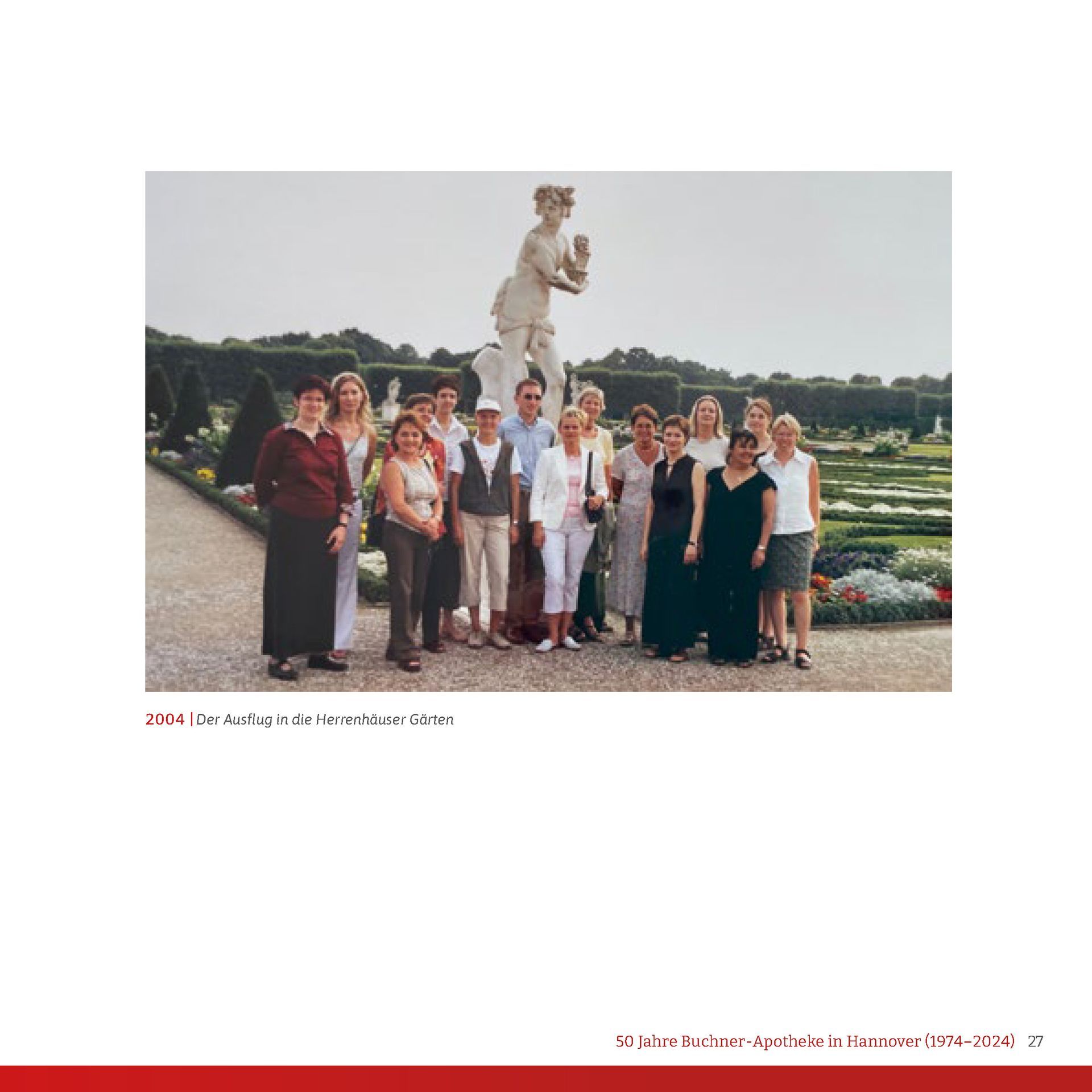 Eine Gruppe von Menschen, die vor einer Statue für ein Foto posieren