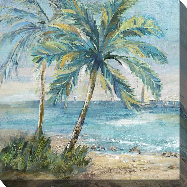 Palm trees on a sandy beach beside turquoise water under a bright sky.