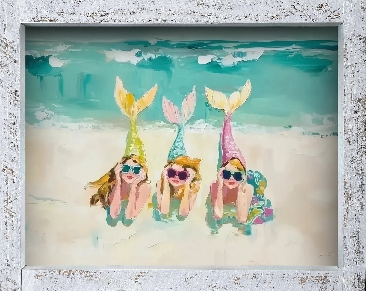 Three colorful mermaids with sunglasses float in teal water in a framed painting.