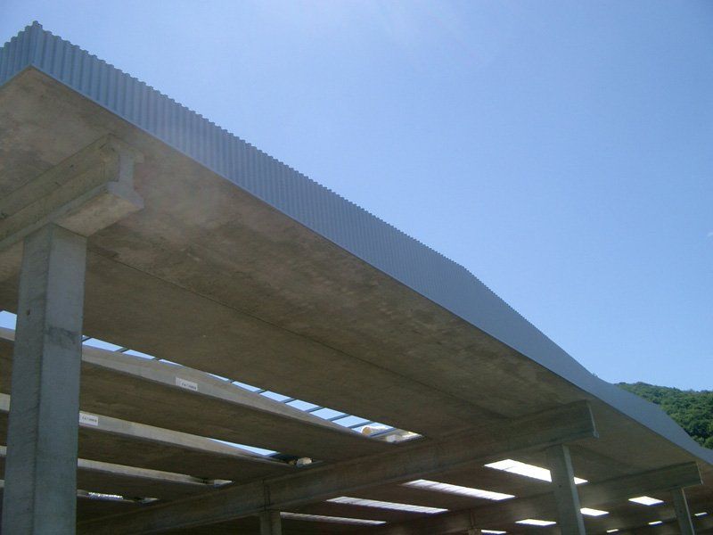 Struttura di parcheggio in cemento in costruzione sullo sfondo di un cielo azzurro.