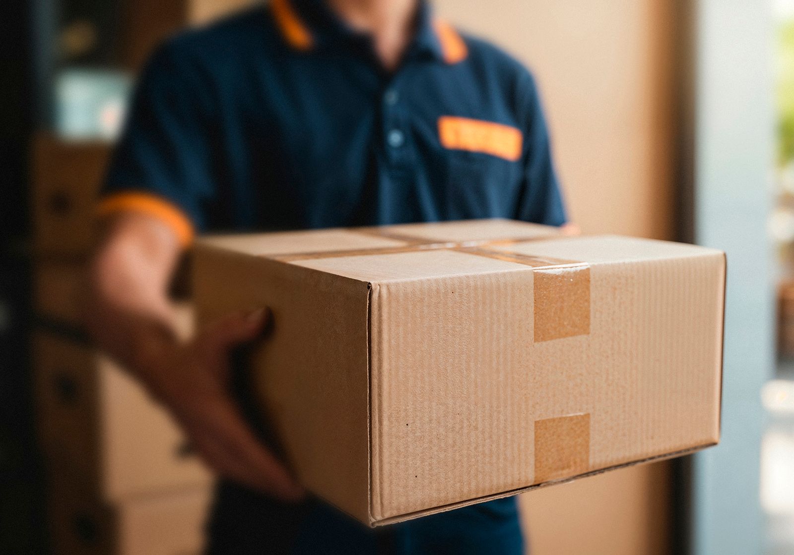 Repartidor sosteniendo una caja de cartón.
