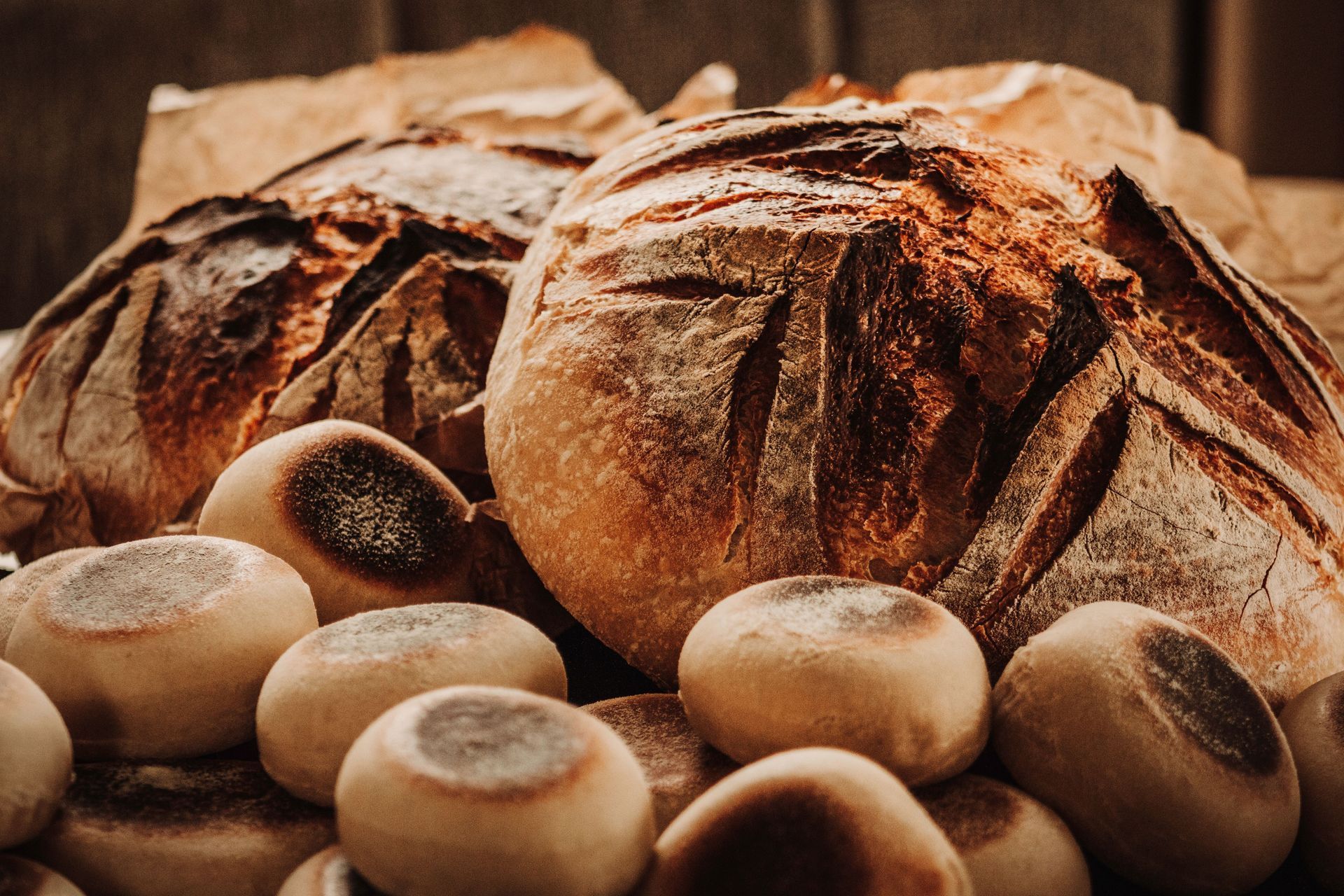 Fresh rustic loaves of bread and rolls arranged together on a wooden surface
