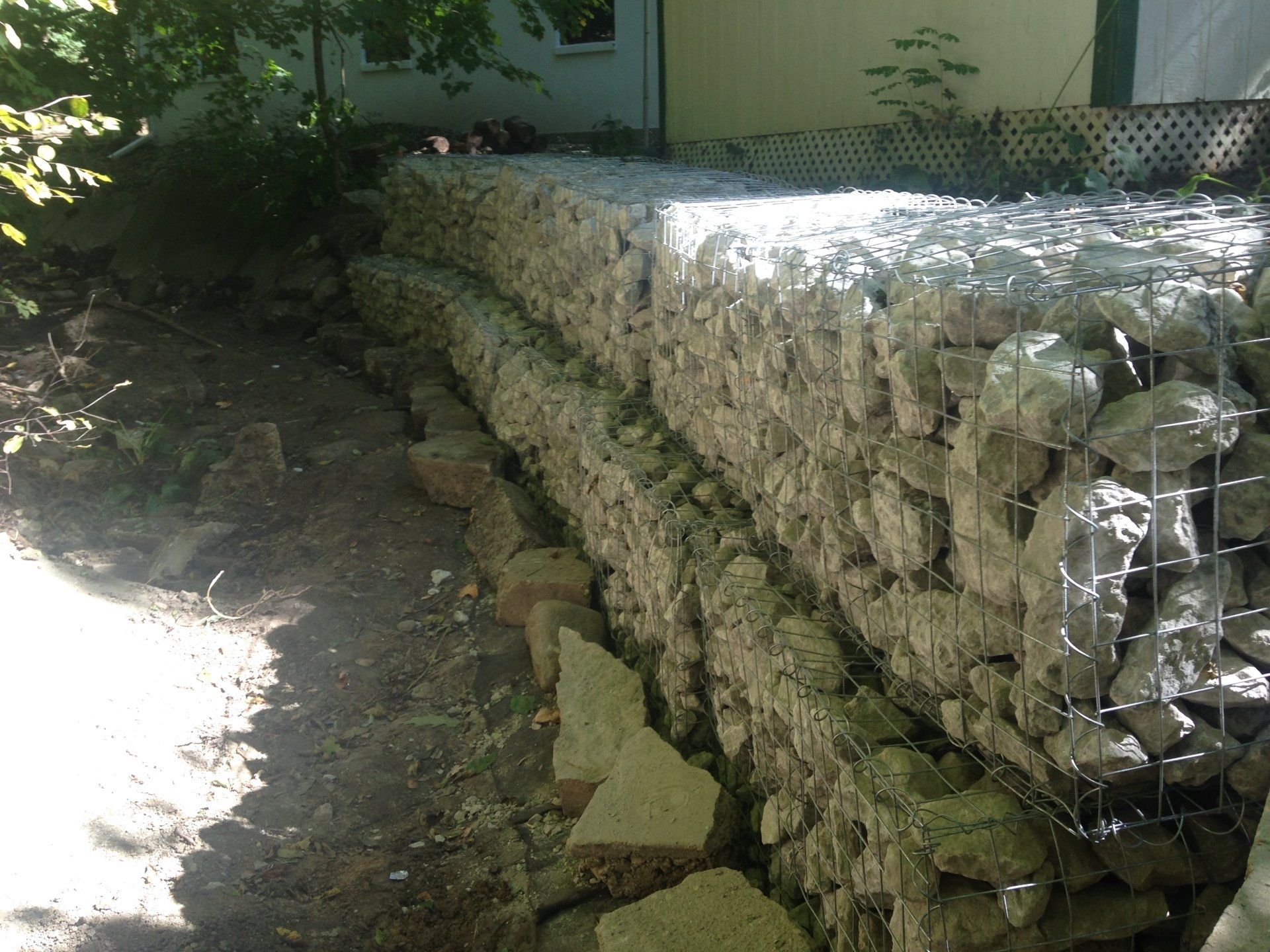 A stone wall is being built in front of a house