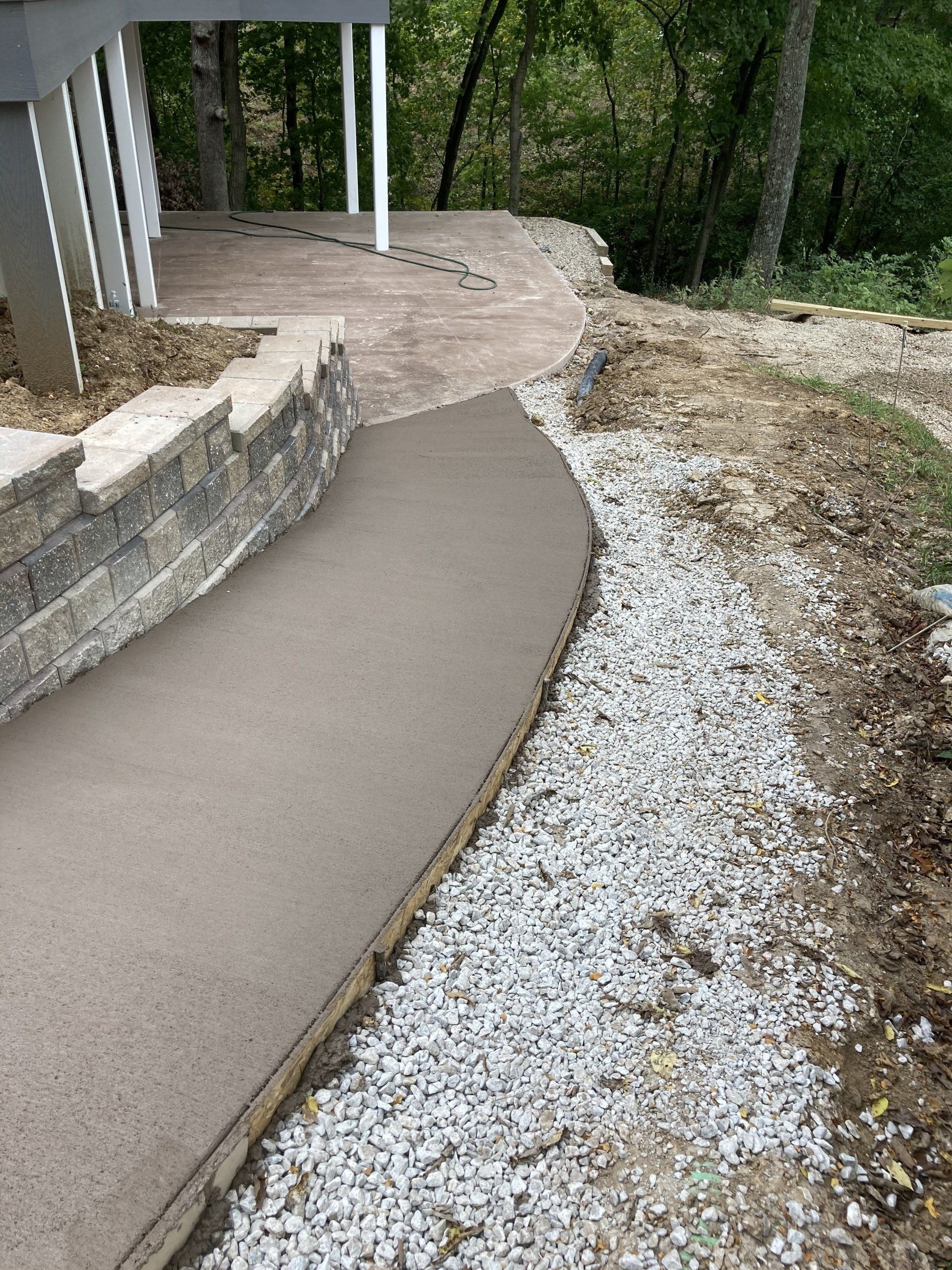A concrete walkway is being built next to a pile of gravel.