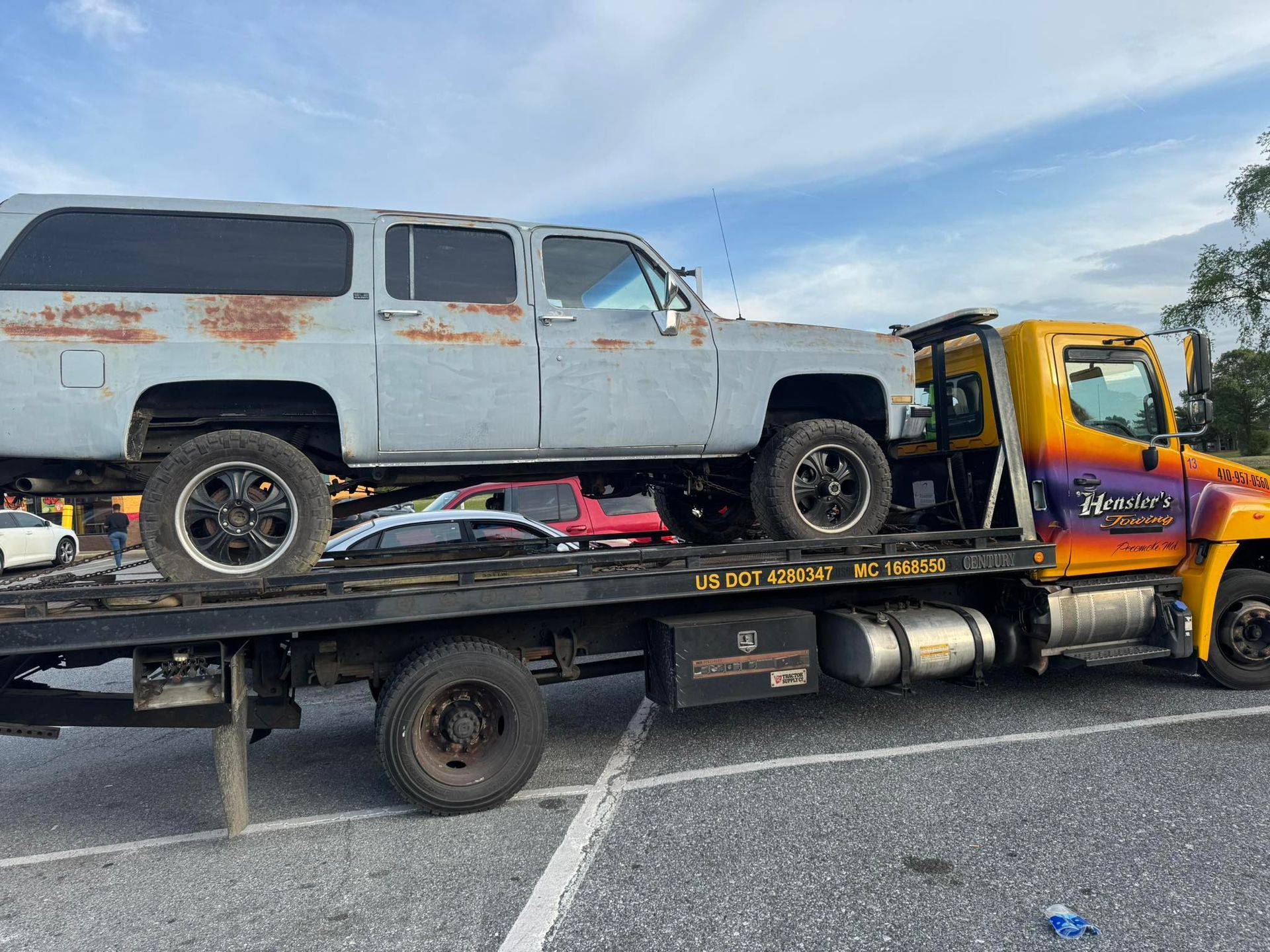 Gray SUV on a flatbed tow truck with the 