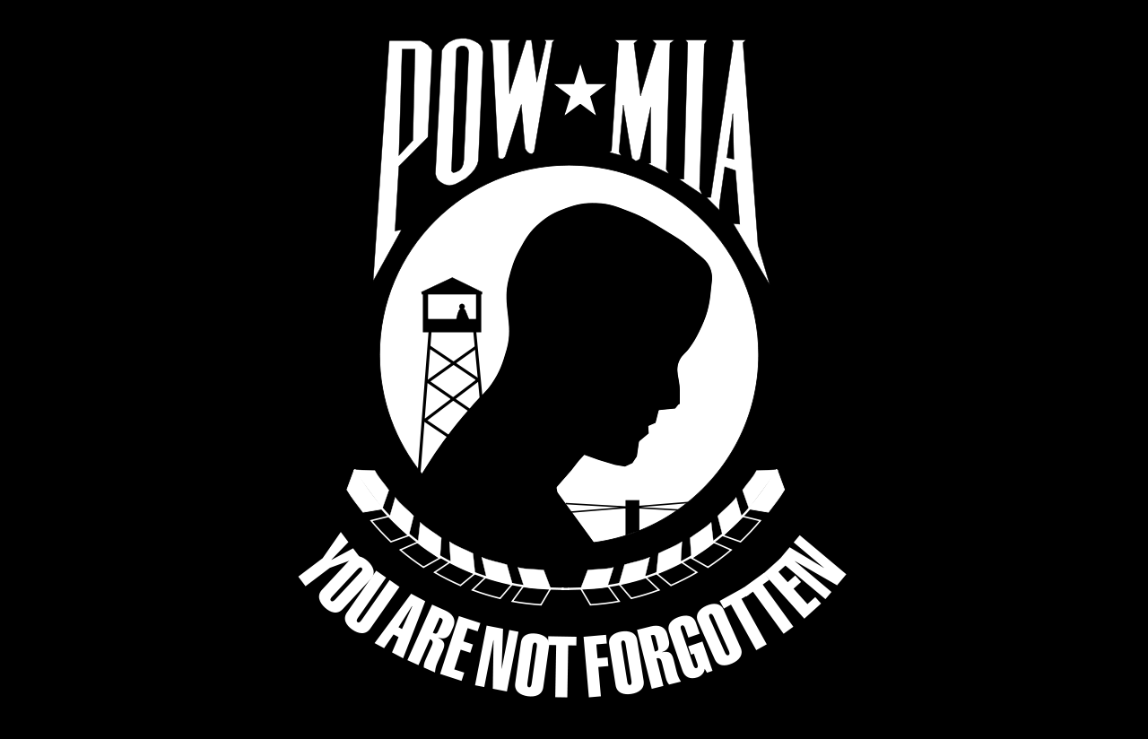 Black and white POW/MIA flag with a prisoner silhouette, watchtower, and the phrase