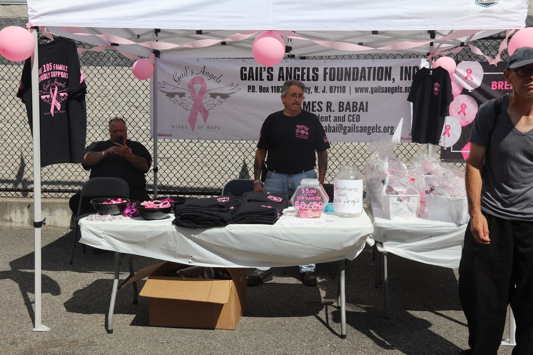 People at a booth for Gail's Angels Foundation, with pink ribbon décor.