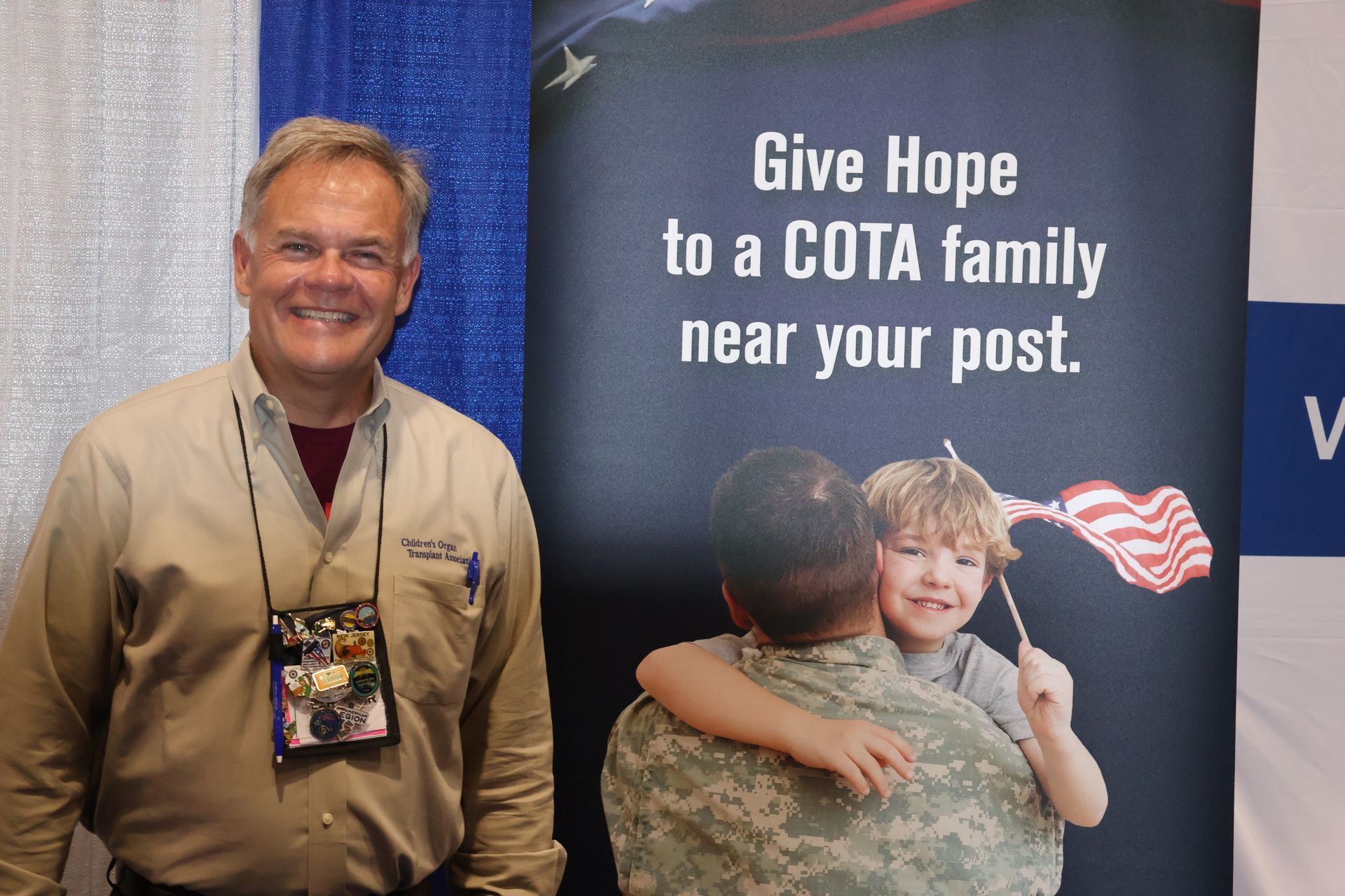 Man standing next to a banner reading 
