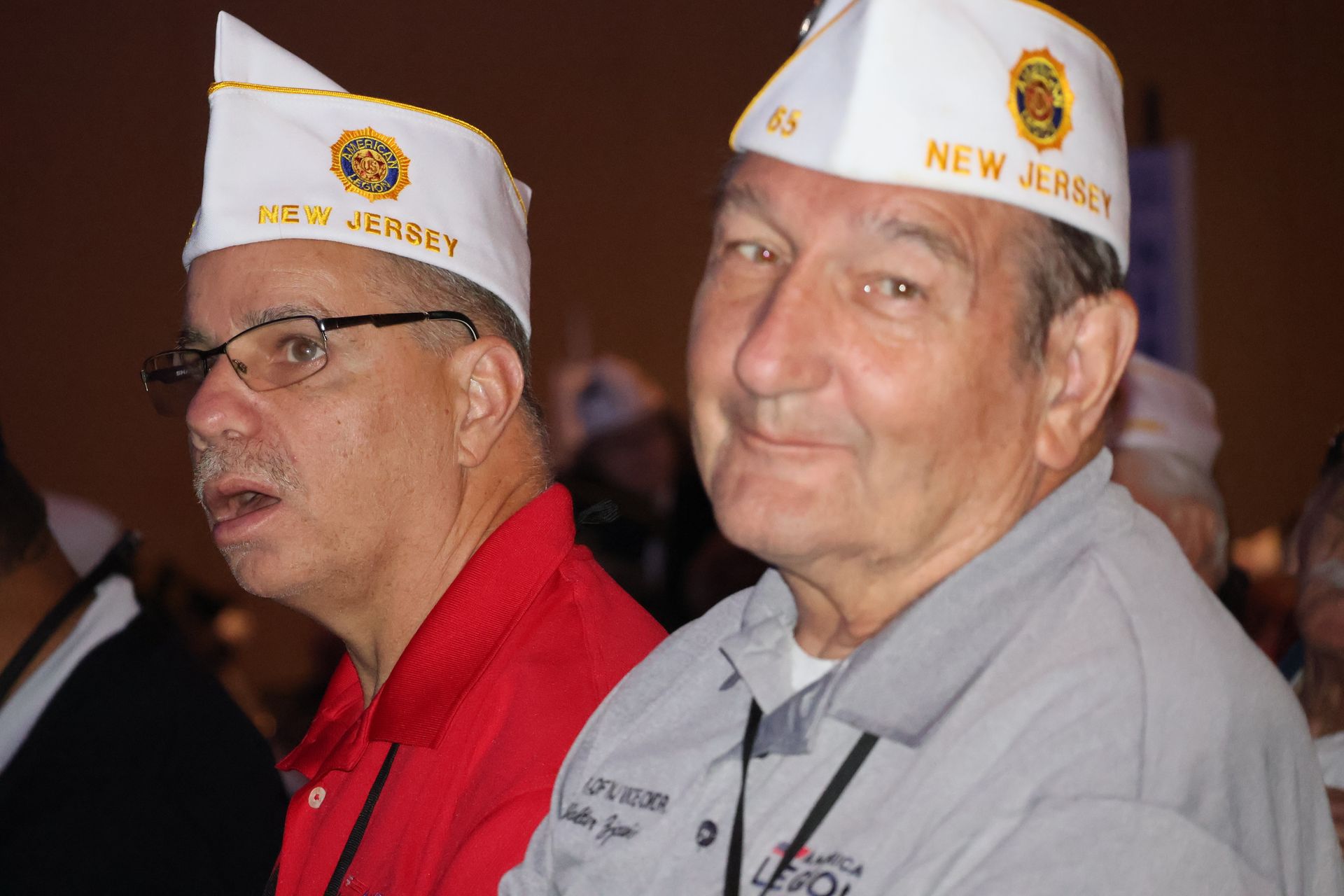 Two men wearing white hats that say 