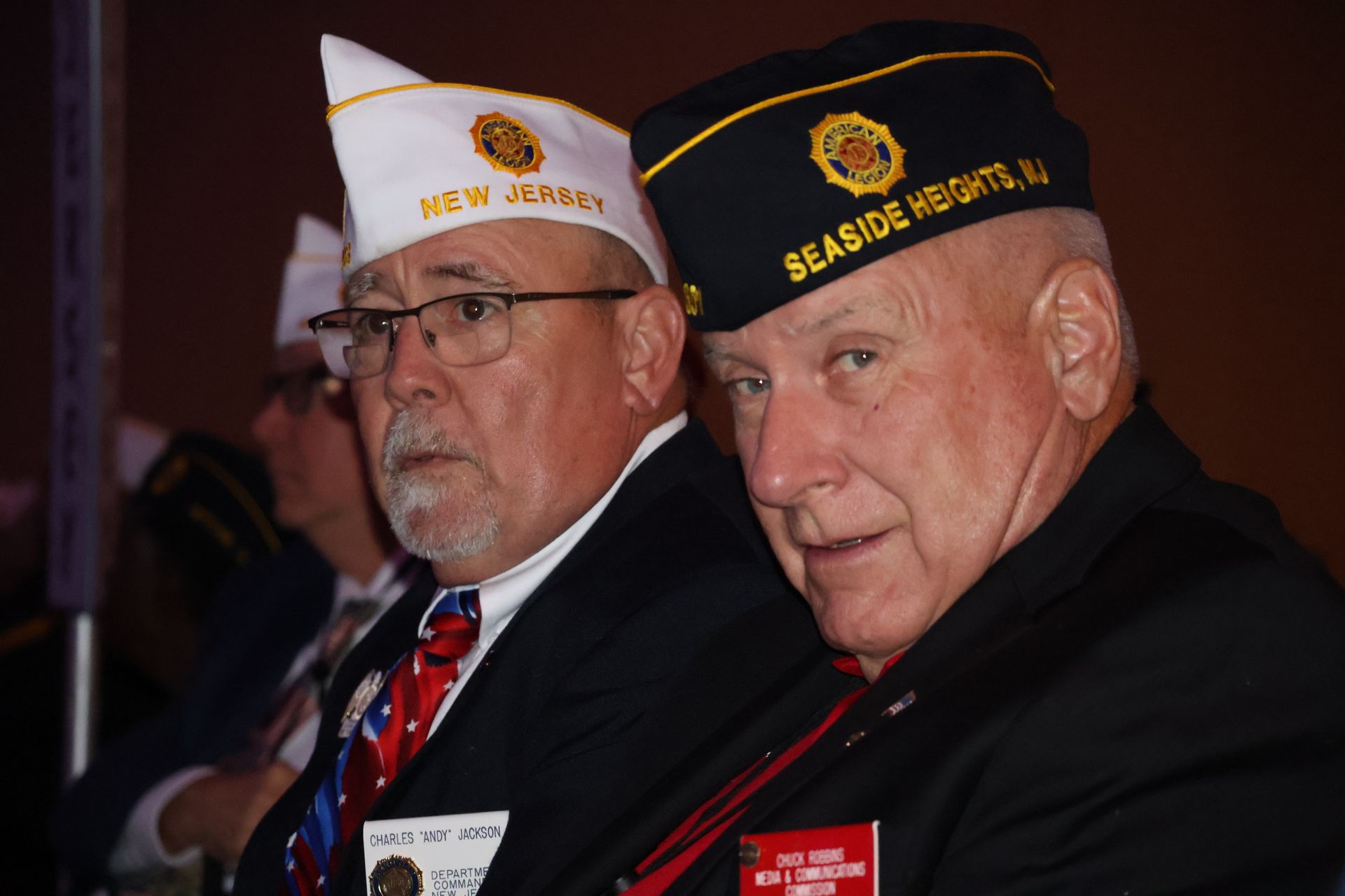 Two men in veteran hats, one marked 