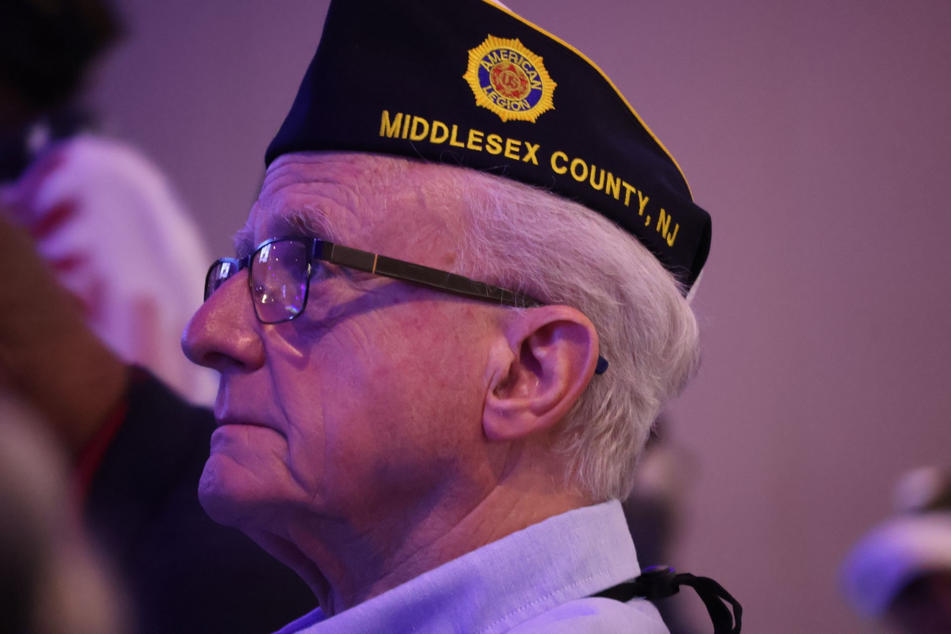 Man wearing eyeglasses and a hat that says 