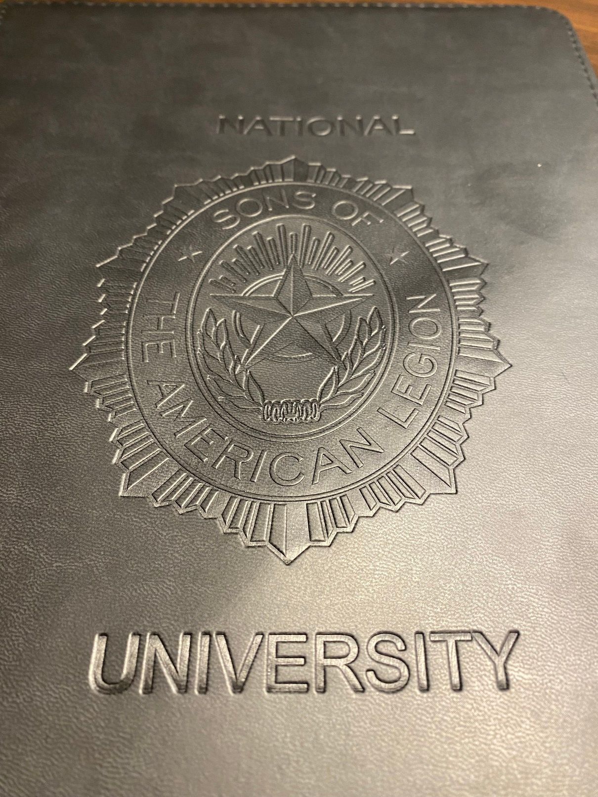 Black embossed cover with text and seal: 
