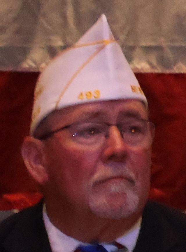 Man wearing white, pointed hat with 