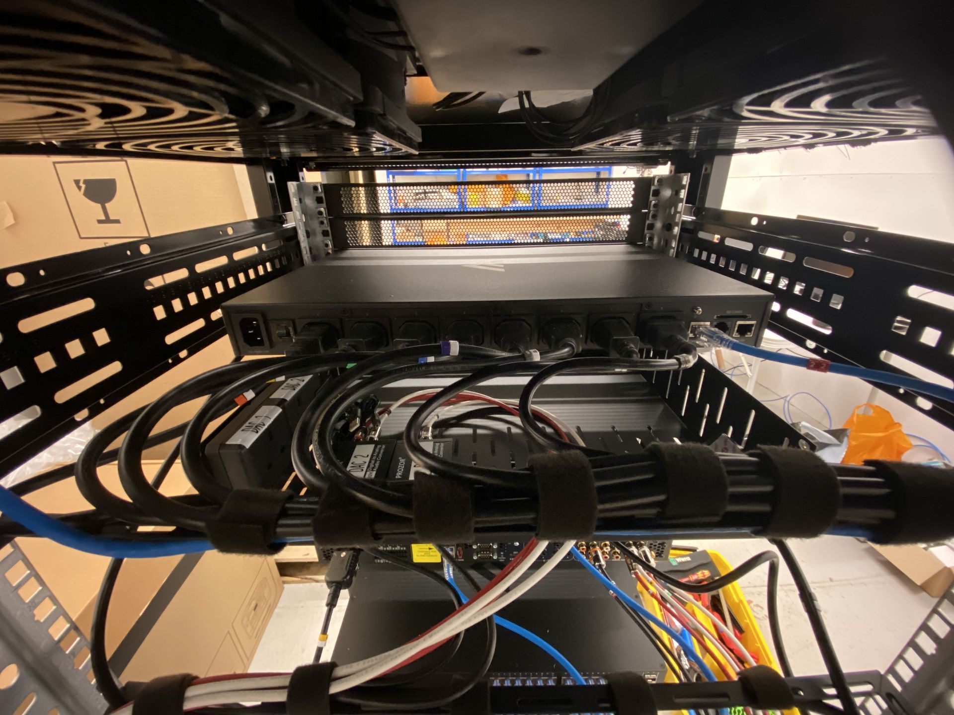Network server rack with black cables, rack-mounted devices, and organized cabling.