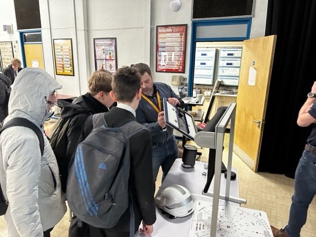 A person showing some school students a speaker