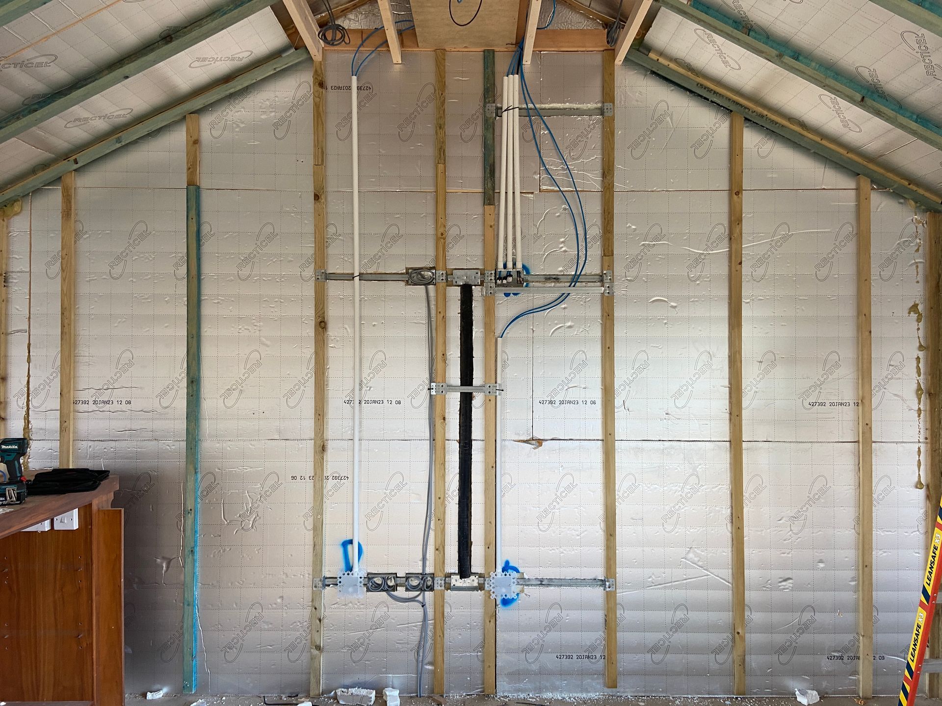Photo of a TV Point back box behind location of future TV. A conduit to connect from behind TV to a future media cabinet