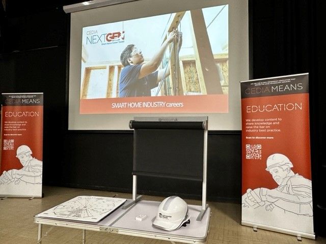 Photograph of a large projection screen showing the CEDIA NextGen Presenation on it
