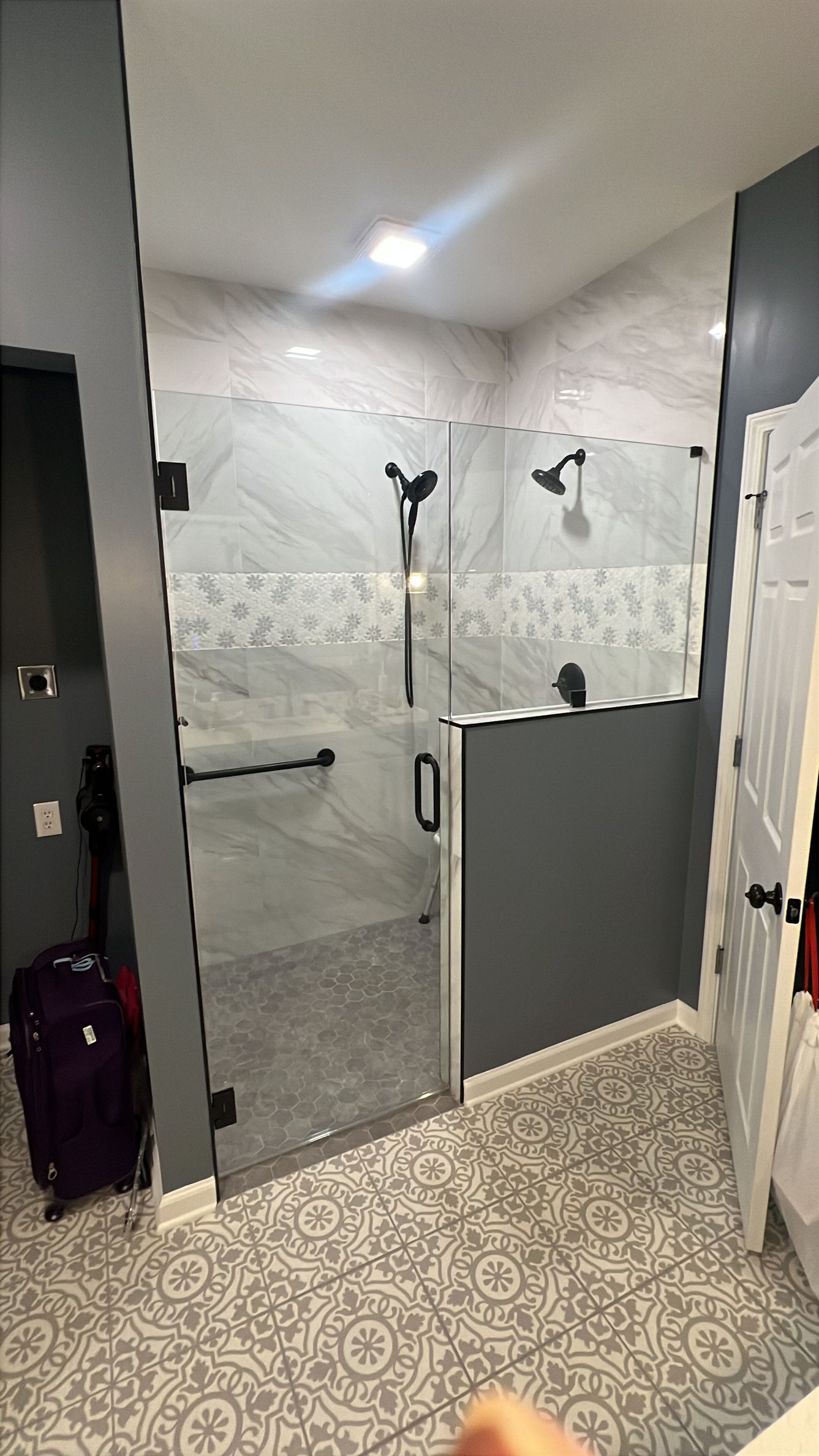 Three-panel glass shower enclosure with matte black hardware in a Sharpsburg, GA home