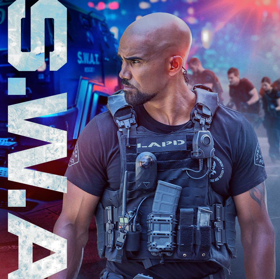 A man with a beard is wearing a vest that says s.w.a.t.