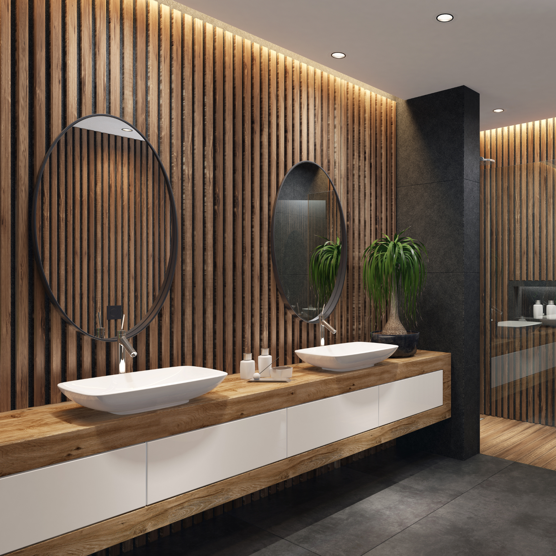 Modern bathroom with wood paneling, oval mirrors, white sinks, and a potted plant.
